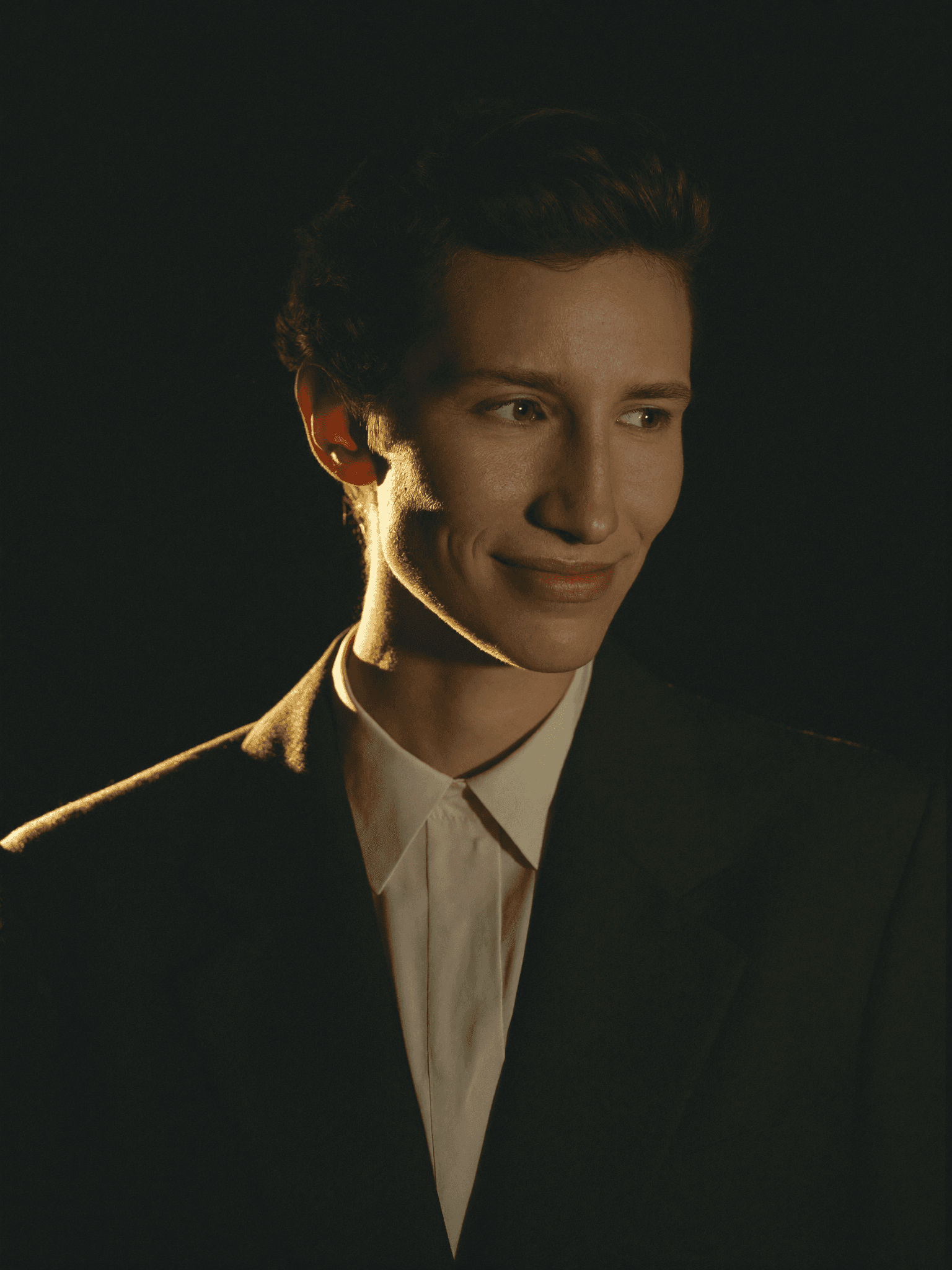 Portrait of an Obsidian Affiliates partner, warm gold rim light on black